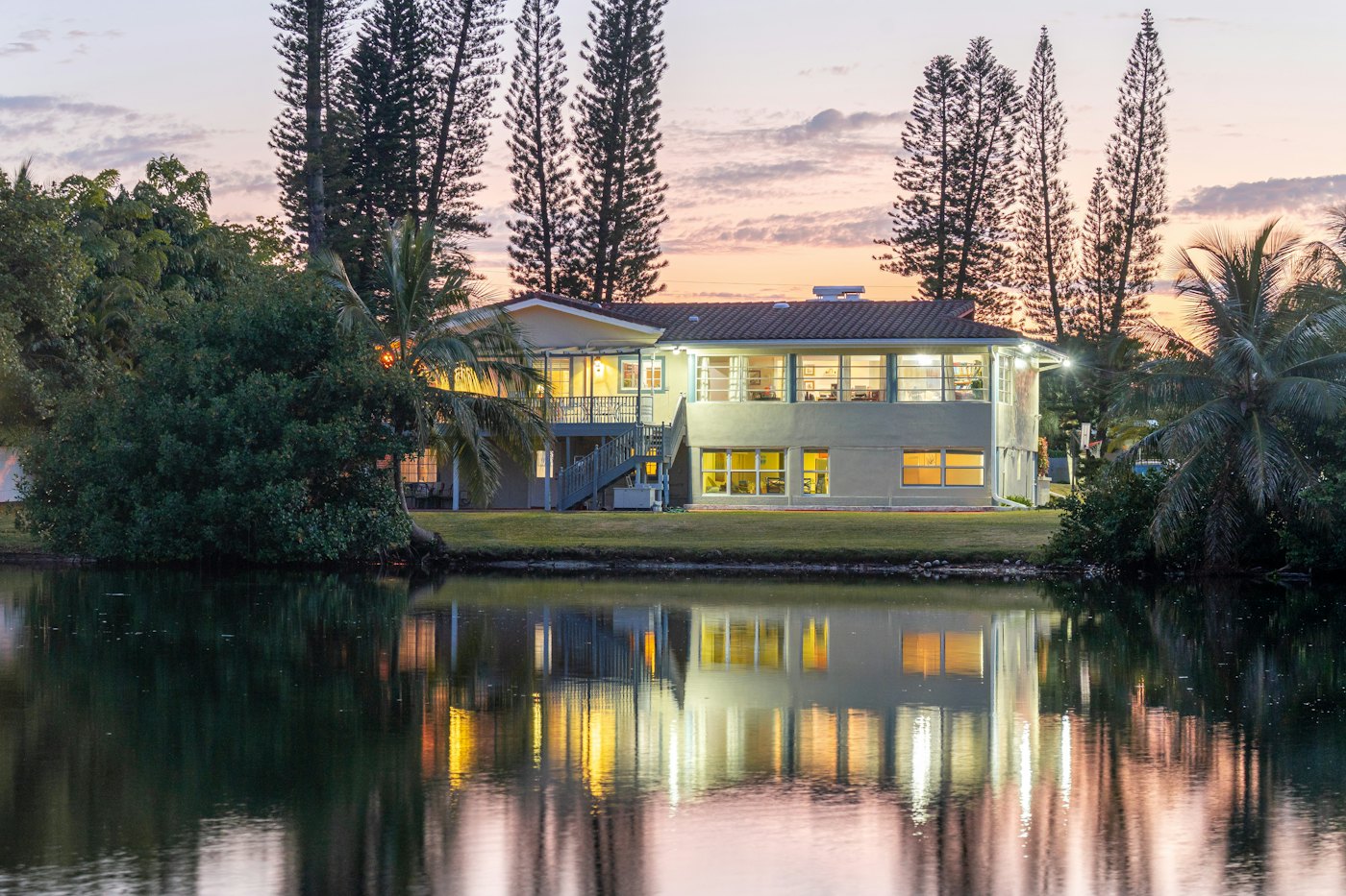 Lakefront house at sunset reflected in still water